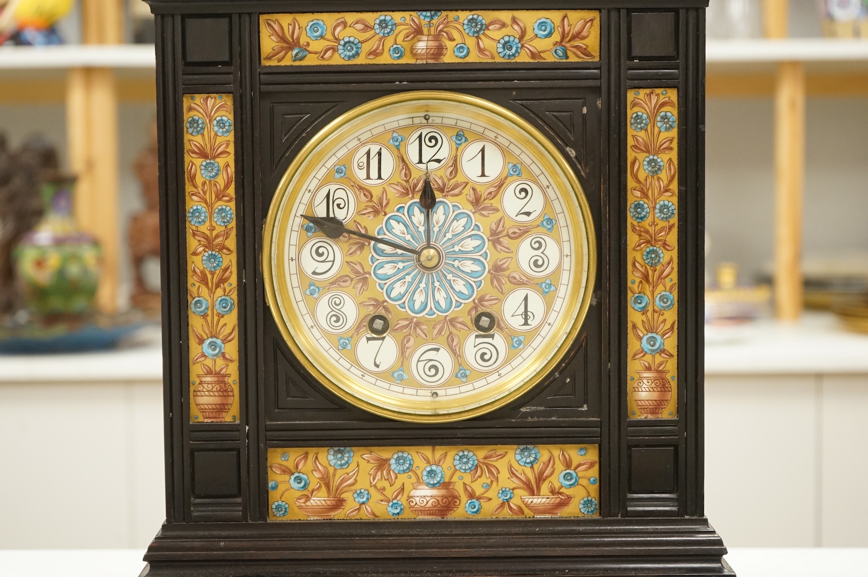 A Victorian Aesthetic Movement ebonised architectural mantel clock, probably designed by Lewis Foreman Day, the eight day chiming movement marked G.V. no. 39837, with Elourdelet lever, with figure and foliage decorated g